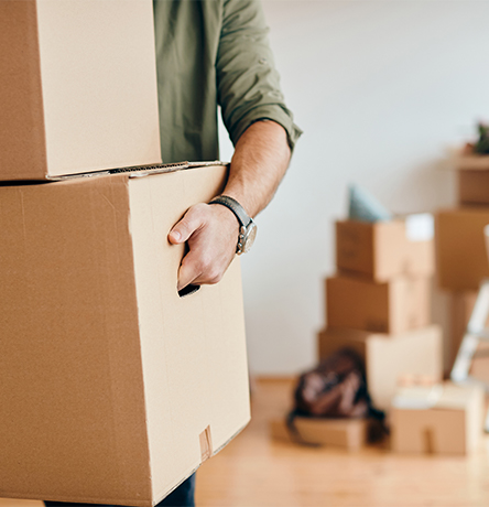 closeup-man-carrying-cardboard-boxes-while-relocating-into-new-apartment marco